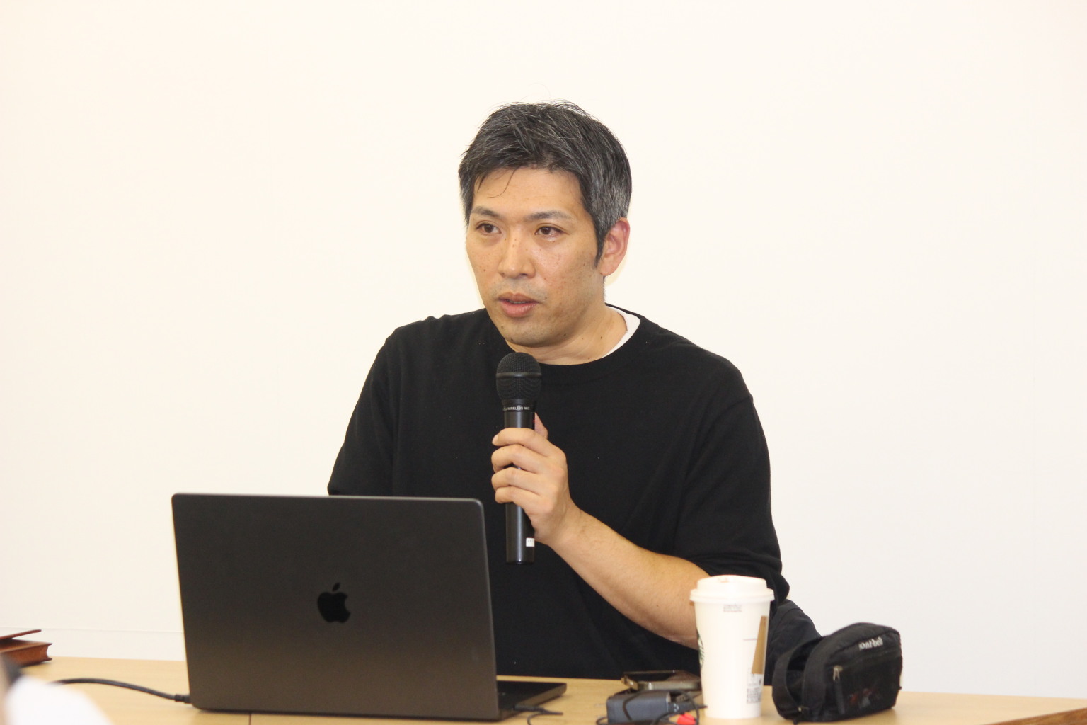 ノートパソコンを使い、マイクを手に説明する白石 淳二（しらいし じゅんじ）氏