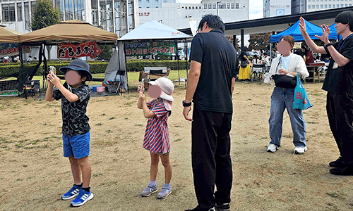 にこにこマルシェの会場で、子どもがXR（AR）体験を楽しんでいる様子