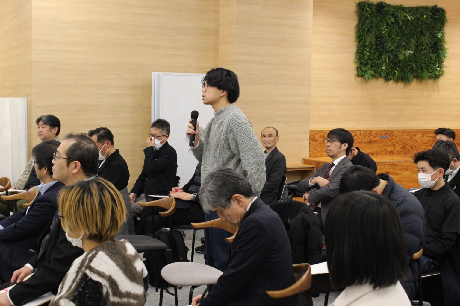 参加者がマイクで質問し、会場で質疑応答を行う様子
