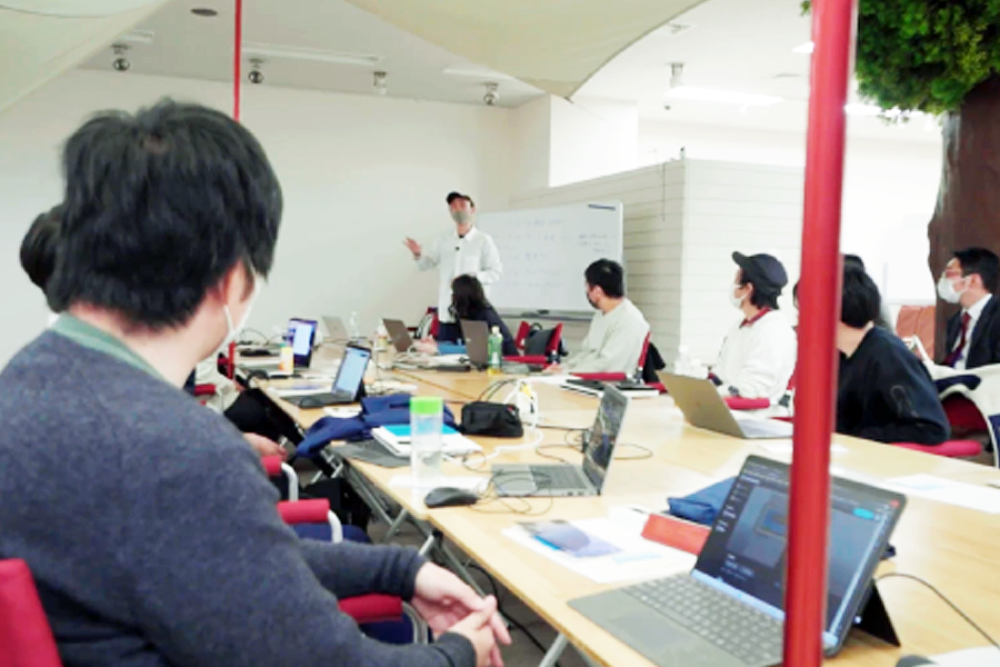 山形XRスクールで講師の説明を聞く受講者とノートPCで学ぶ参加者たち