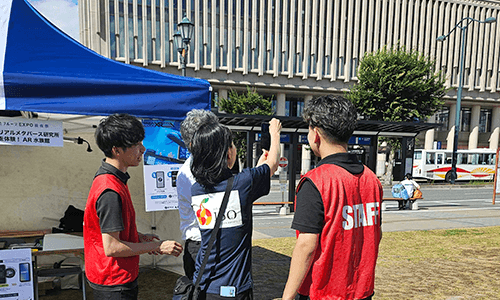 スタッフが来場者にAR水族館の体験方法を説明している様子